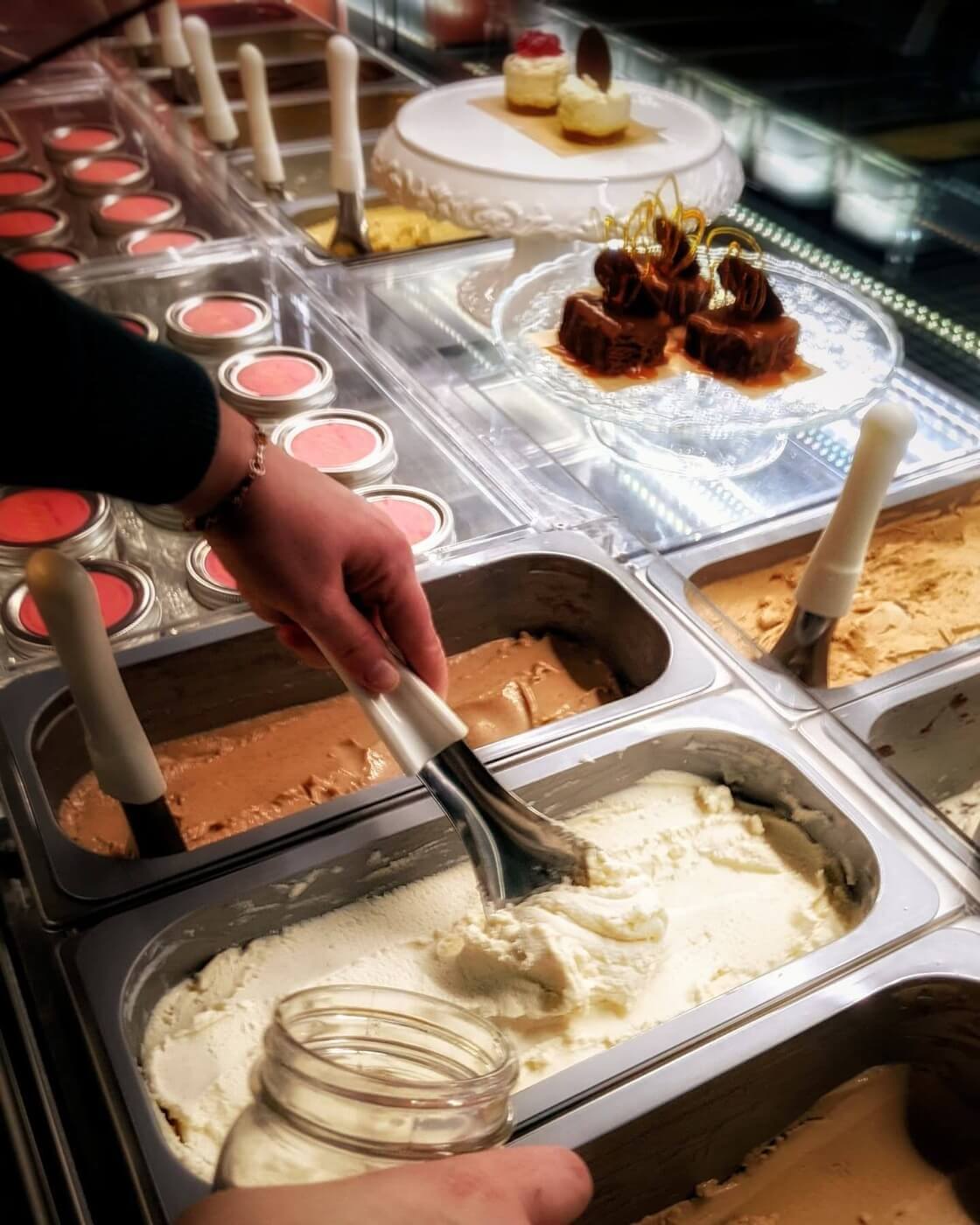 The serving case at Gina's Gelato showing traditional gelato kept level with the pan rims for proper temperature control.